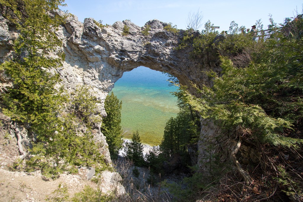 Famous seastack on Mackinaw Island known as Arch Rock with the azure waters of Lake Huron in the background.