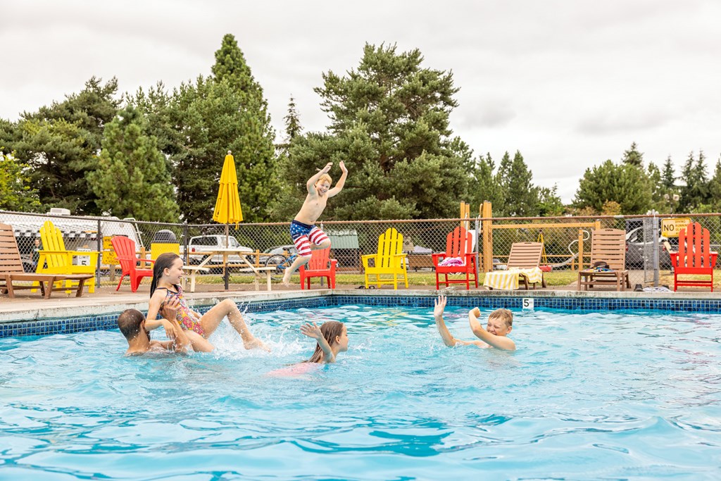A family splashes in the pool at a KOA campground.
