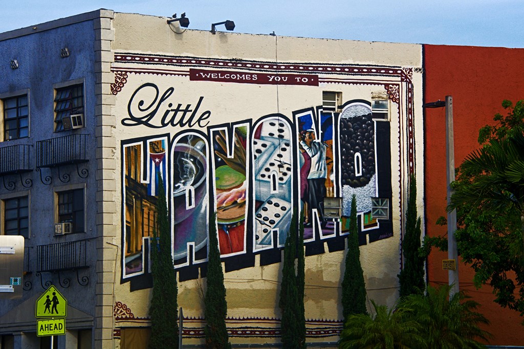 A mural that says "welcomes you to Little Havana" appears on the side of stone building.