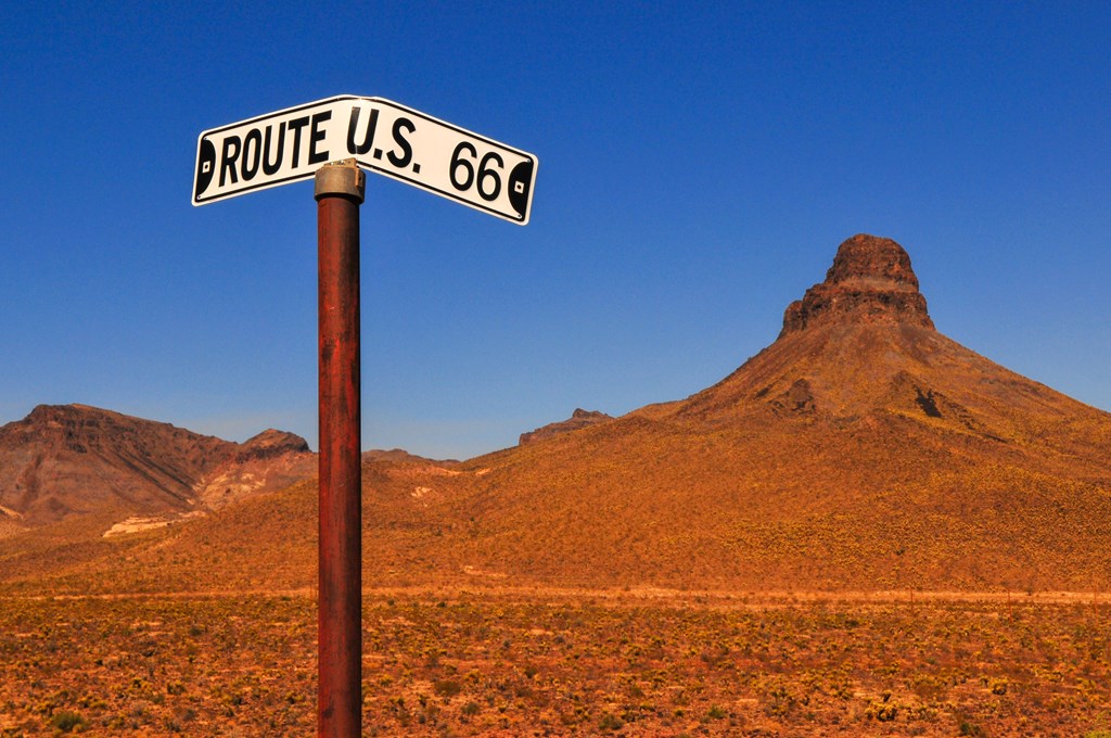 A bent road sign on the Historic Route 66 through the harsh desert terrain between Kingman and the wild west gold mining town of Oatman, Arizona, Southwest USA.