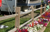 RV site by flower wall