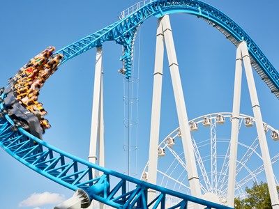 People riding a large blue and white roller coaster at Legoland in San Diego, California.