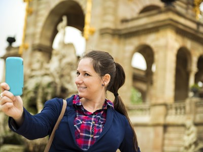 Woman takes a selfie in front of one of the historic buildings while on a Tour of Old Town San Diego.