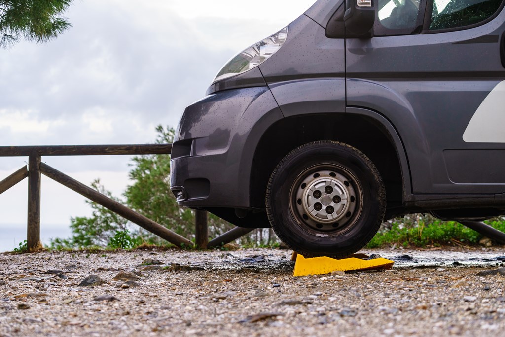 Camper leveling yellow block in use. Leveler ramp chock blocks for rv travel trailer. Accessories for motorhome.