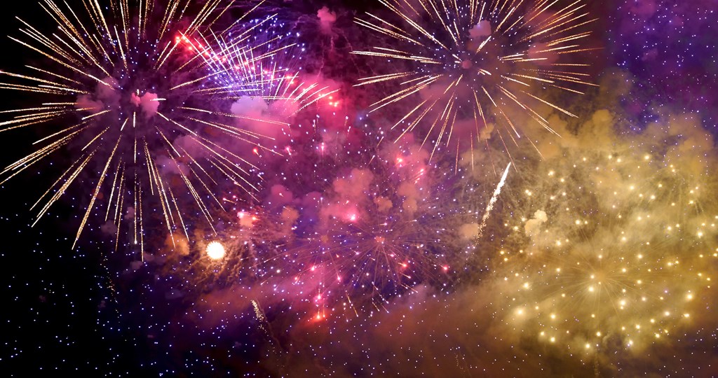 Purple and yellow fireworks in the night sky