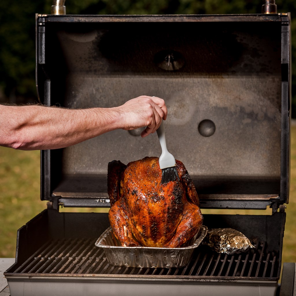 Basting a Turkey on a BBQ with a brush