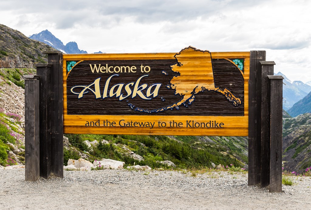The Welcome to Alaska and the Gateway to the Klondike sign in Alaska, America in the cloudy day.