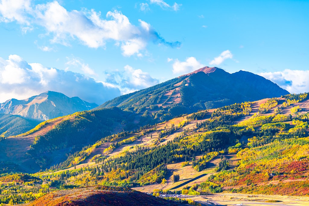 View of Aspen city, Colorado USA and buttermilk ski slope hill in rocky mountains peak with colorful autumn foliage aspen trees in Roaring Fork Valley.