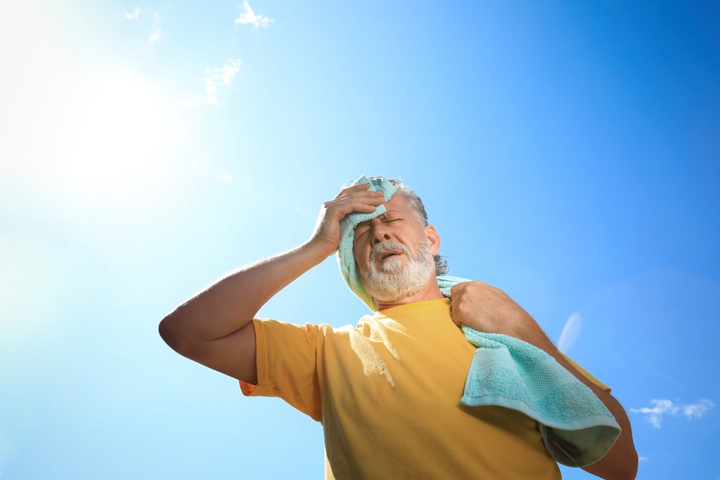 Senior man with towel suffering from heat stroke 