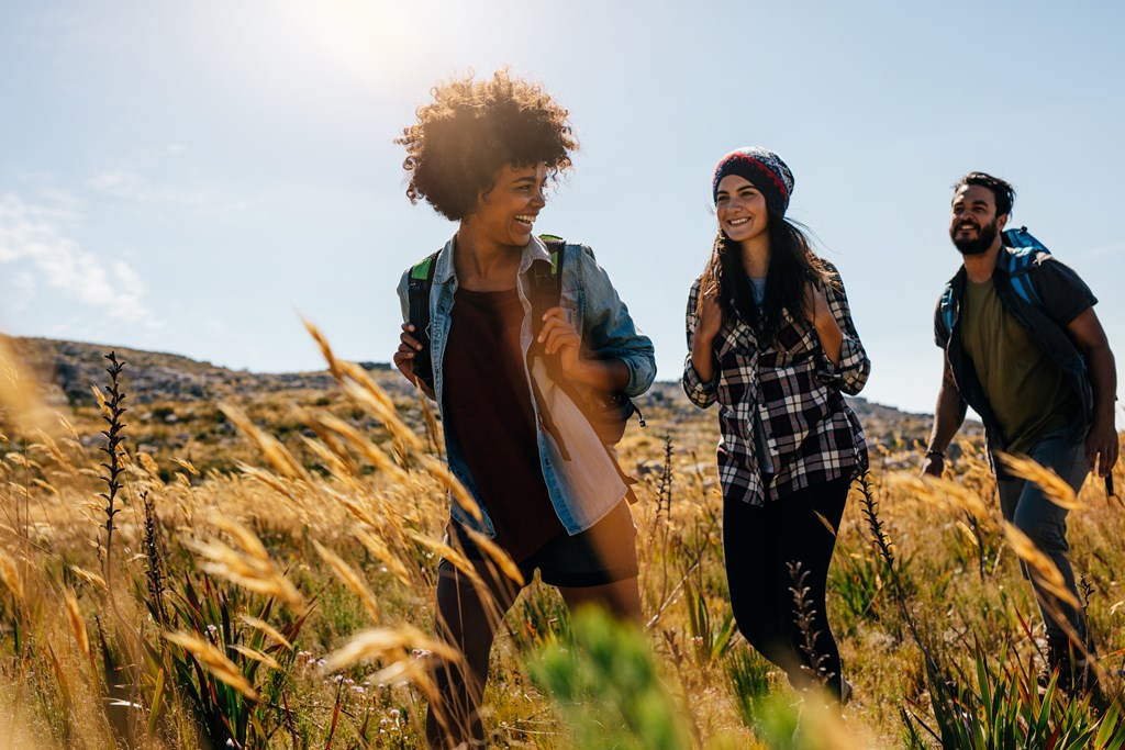 Happy group of friends hiking together on a summer day.