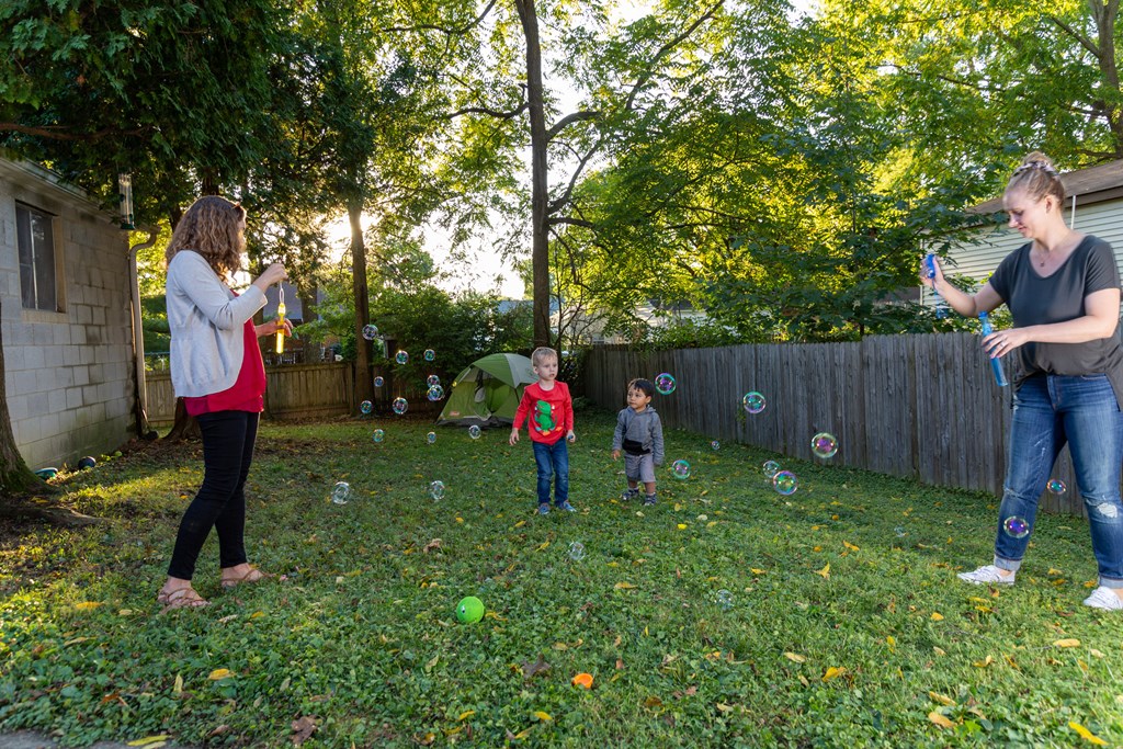 A family blows bubbles during a backyard camping day.