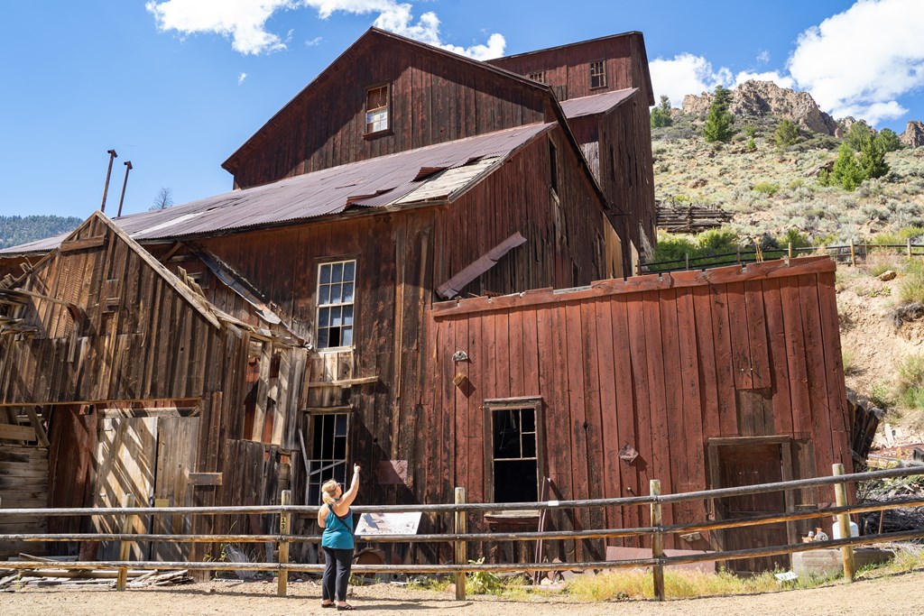 Woman tourist explores the old mining ghost town of Bayhorse Idaho in the Salmon-Challis National Forest