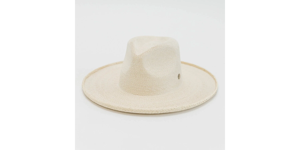 Cream-colored straw fedora hat on a cream background.