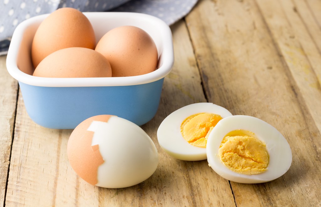 Hard boiled chicken eggs on rustic wooden table.