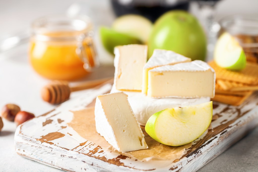 Wedges of brie cheese with sliced green apple.