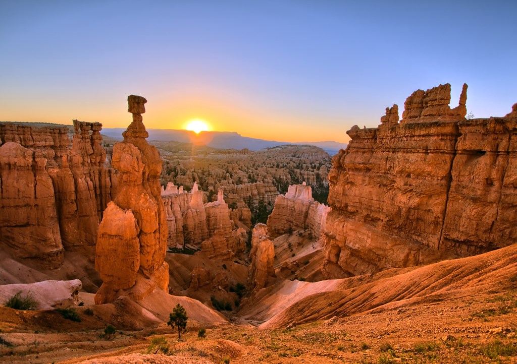 The sun rising above red rock formations at Bryce Canyon National Park, Utah.