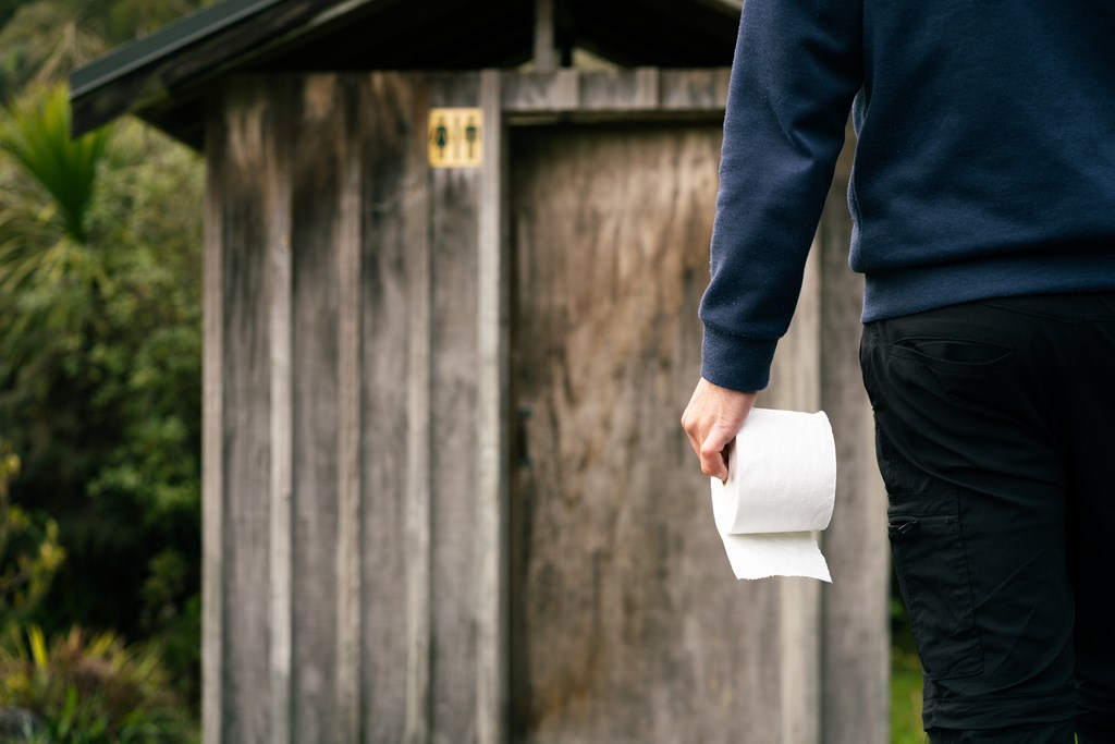 Person holding toilet paper about to enter a public outdoor toilet sets the scene for this creepy story for kids