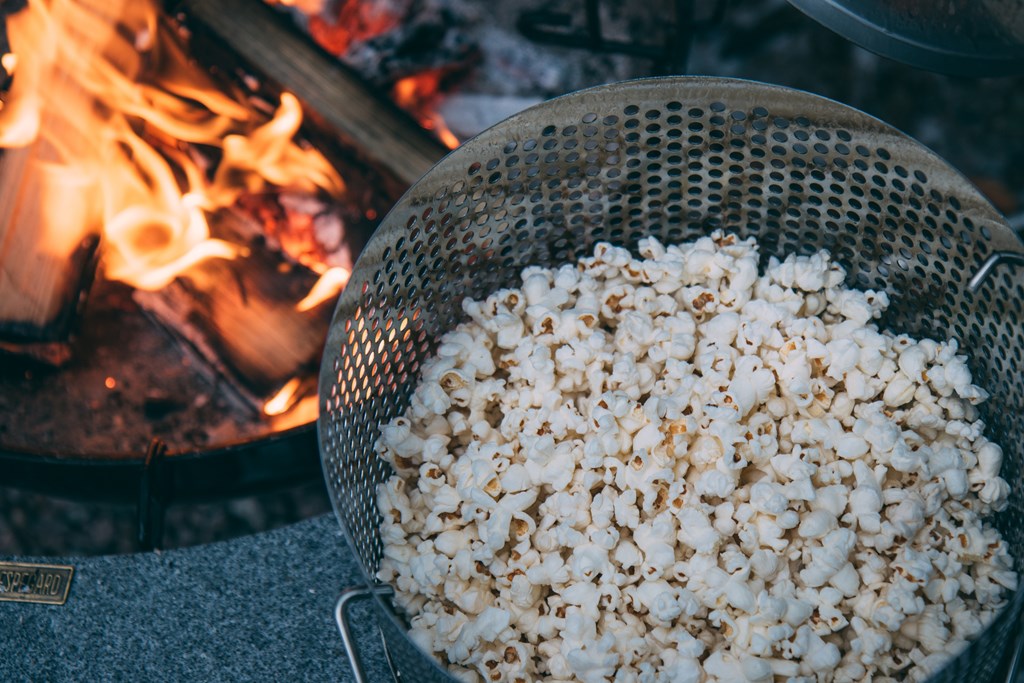Popcorn near a roaring campfire.