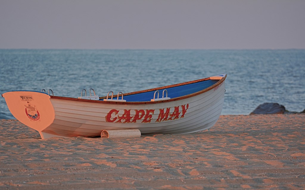 Wooden lifeguard boat on a sandy beach.