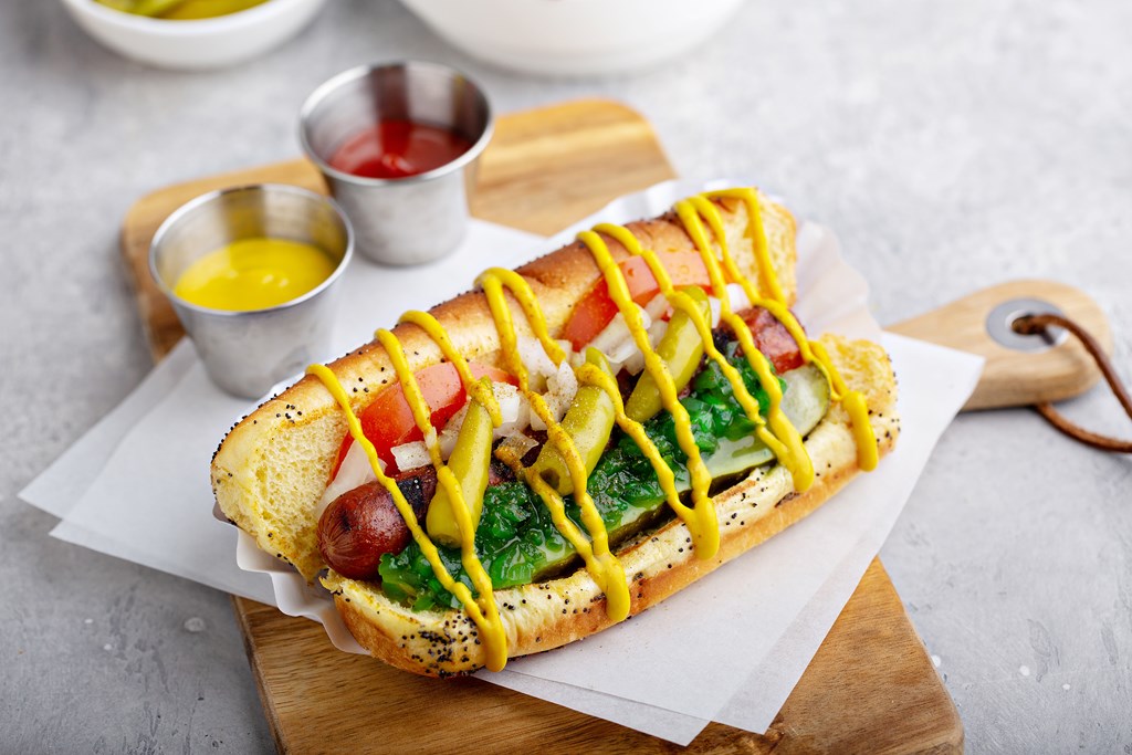 Chicago hot dog on a poppy seed bun topped with tomatoes and sweet relish.