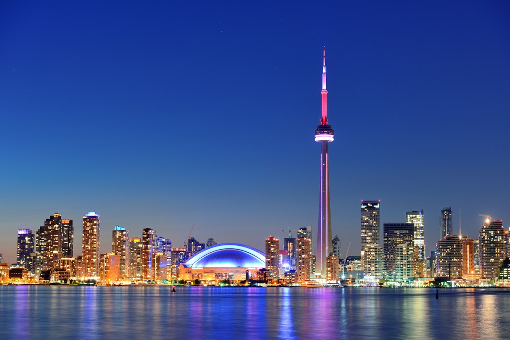 The city of Toronto rises from the lake at twilight.