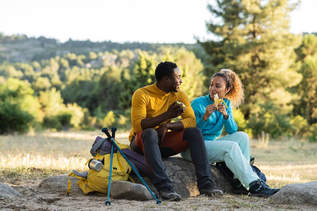 Couple taking a snack break during a hiking trip.