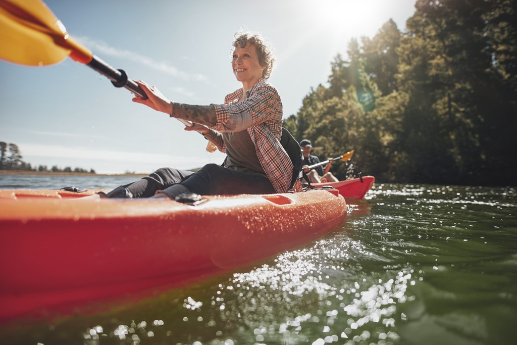 Adults kayaking on the lake in summer