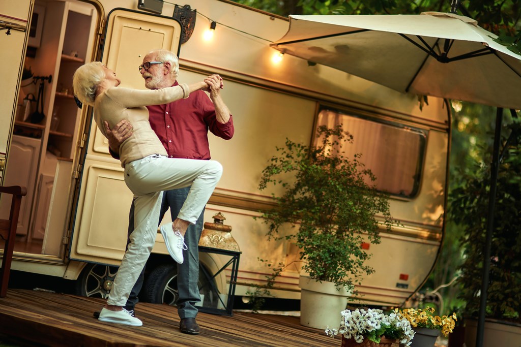 Senior couple dancing in front of an RV.