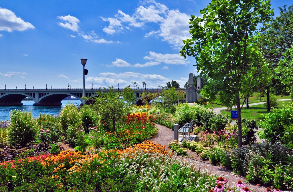 Green gardens with a walkway meandering down the middle on the riverfront in Detroit.