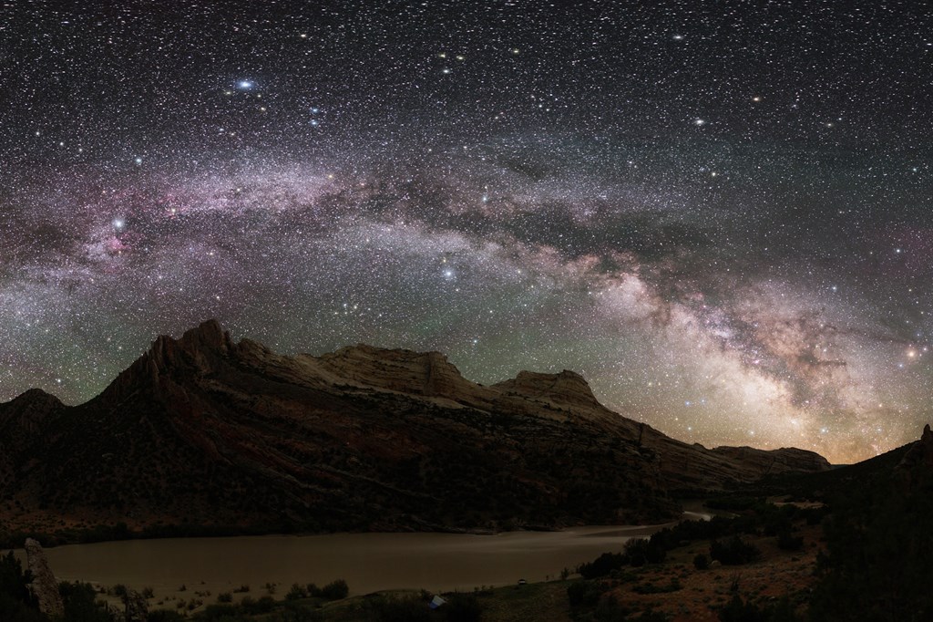 The stars and Milky Way shine bright over the rocky mountains of Dinosaur Land National Monument.