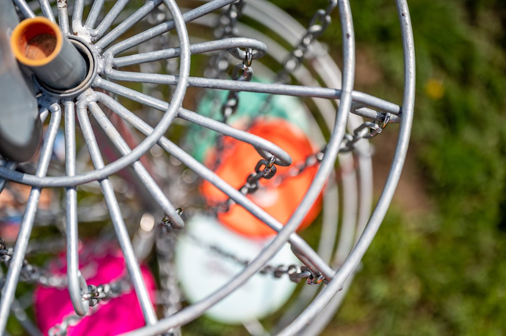 Top view of a golf basket chains with discs blurred below - narrow focus