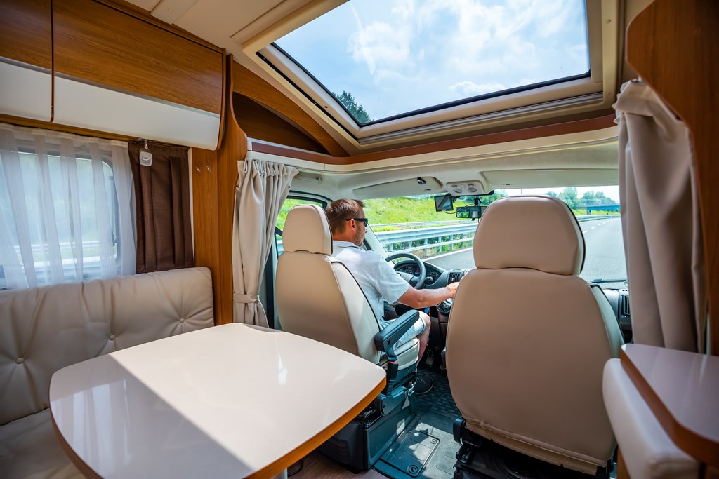 Interior shot of a man driving an RV down the road.