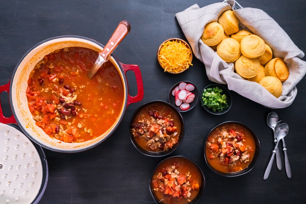 Turkey chili garnished with fresh radishes, green onions and cheddar cheese