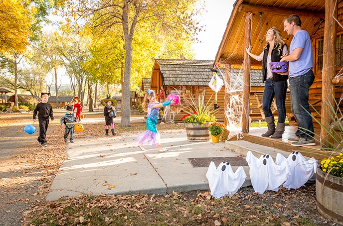 Kids dressed up in Halloween costumes are trick-or-treating.