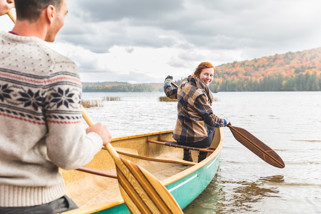 Happy couple canoeing in a lake in Canada. 