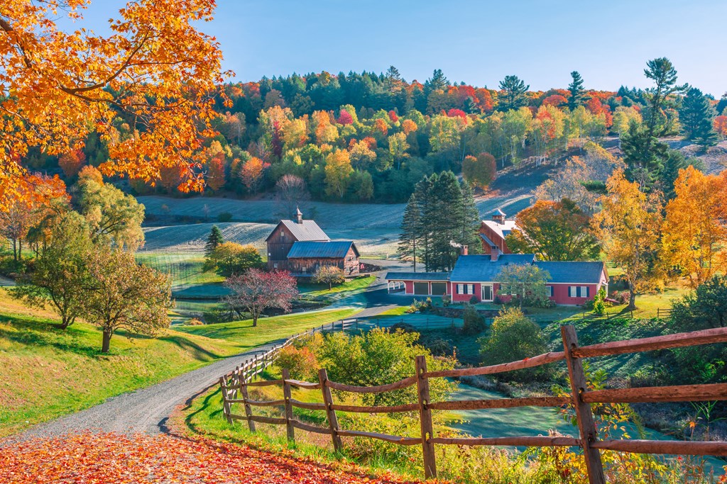 An early autumn foliage scene of houses in Woodstock, Vermont mountains.