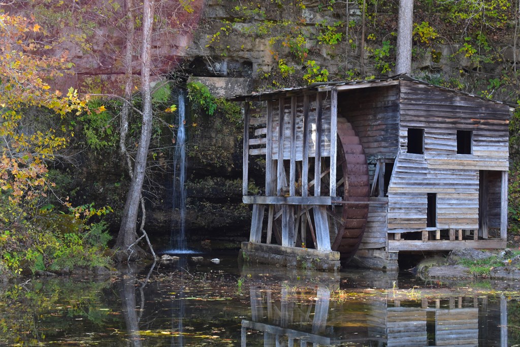 A unique spring located near Winona and Alton, Missouri. The spring flows out from a cave opening in the bluff above. An old mill, and overshot wheel still stand beside the spring.