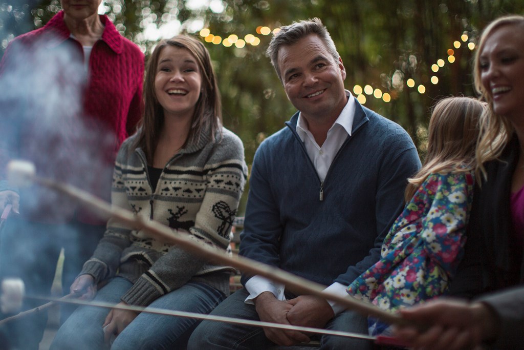 Family roasting marshmallows outdoors.