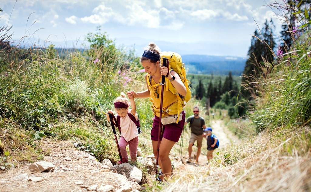Happy family with small children hiking outdoors.