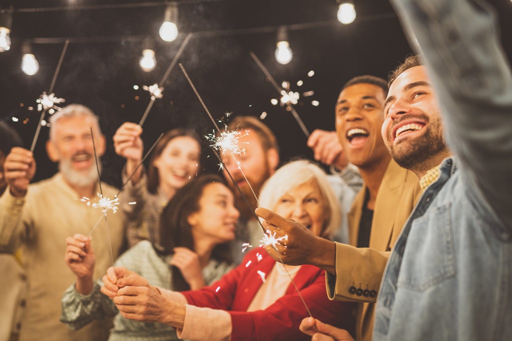 A large family takes a selfie with sparklers.