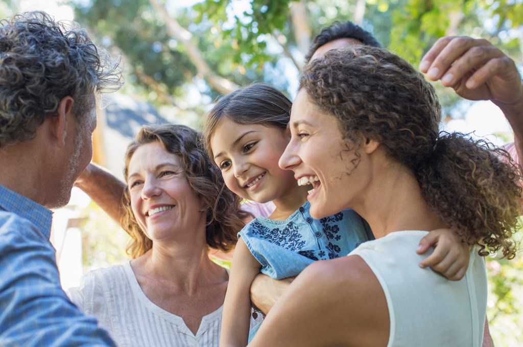 A closeup of family members hugging and welcoming each other.