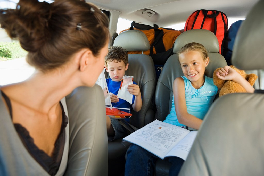 Mother looking at children in backseat of car