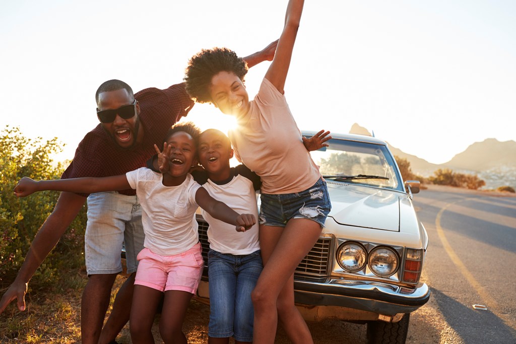 Portrait Of Family Standing Next To Classic Car