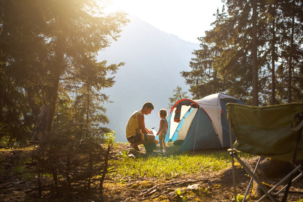 Dad and daughter near a tent.