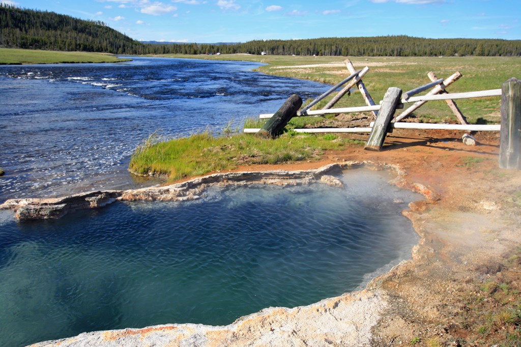 Maidens Grave Hot Spring flowing into the Firehole River in Yellowstone National Park in Wyoming United States