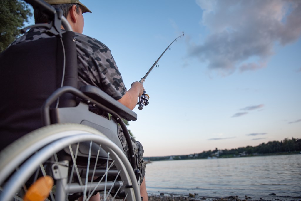 A person who uses a wheelchair fishing.