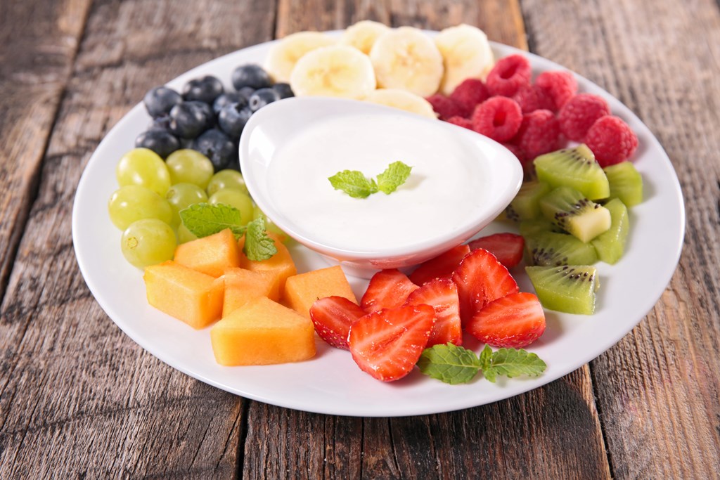 Platter of assorted cut fruit with yogurt dip.