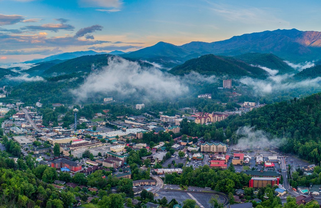 Aerial photo of Gatlinburg, Tennessee with low-hanging clouds at dusk.