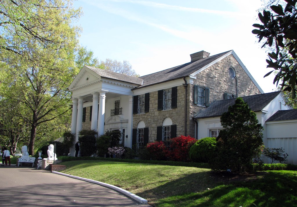 A photo of Elvis's home, Graceland, located in Memphis. A large stone house with white columns.