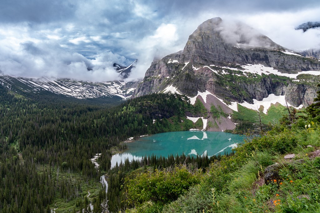 Grinnell Lake in Glacier National Park on a cloudy summer day, with dramatic clouds.